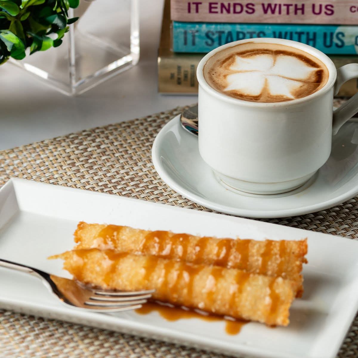 A plated Filipino pastry served with coffee at Café Escudero